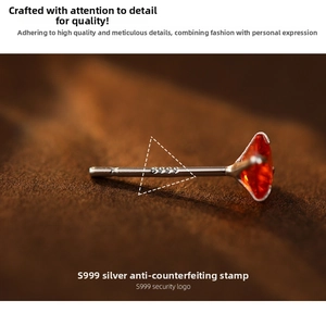 Macro view of S999 sterling silver stud earring featuring an orange gemstone and hallmark