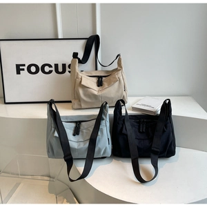 Detailed display of casual canvas crossbody bags in beige, light blue and black colors