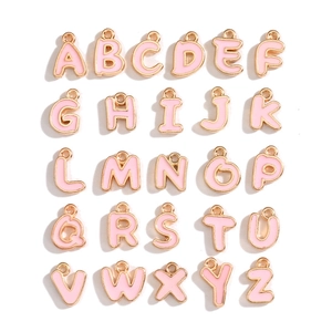 Macro view of 26 pieces pink enamel alphabet charms with golden edges for DIY jewelry