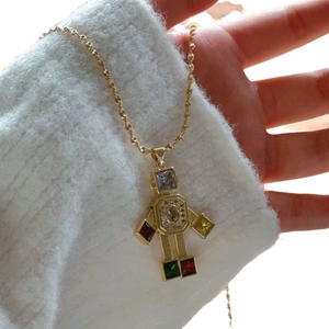 Chic gold robot pendant necklace with colorful zircon stones worn on a white sweater