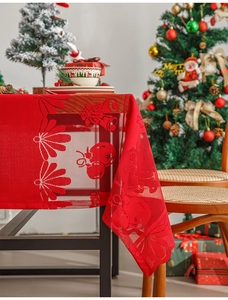 Detail of red hollow lace Christmas tablecloth with festive bells and snowflake patterns