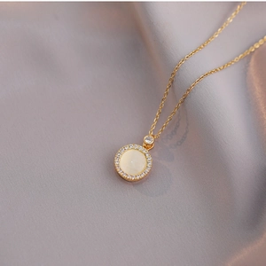 Rotating cat-eye stone necklace in gold titanium steel with zircon halo on silk background