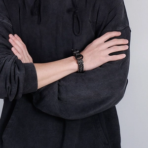 Detail view of a men's woven dragon chain bracelet in antique black metal finish