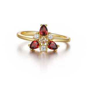 Macro view of S925 silver ring featuring pear-cut red garnets and white diamond details