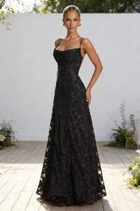 Close-up of intricate black lace embroidery and thin straps on a backless evening dress