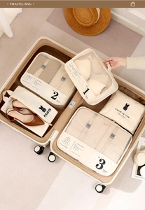 Travel organizer set in pearl white polyester with mesh bags arranged neatly in a suitcase