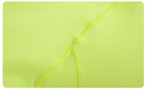 Vue macro des coutures plates et du tissu élastique d'un sweat-shirt vert néon fluo
