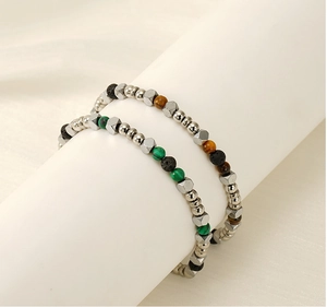 Dettaglio di bracciali con perline di turchese e pietra lavica su un supporto bianco