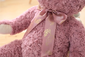 Detailed close-up of rose-textured plush fur and satin ribbon on the teddy bear