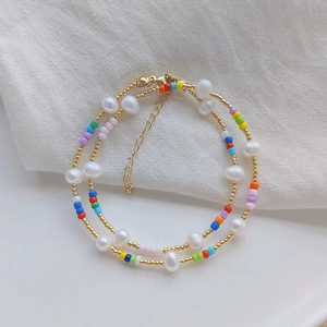 Close-up of colorful beads and irregular white pearls on a summer beaded necklace
