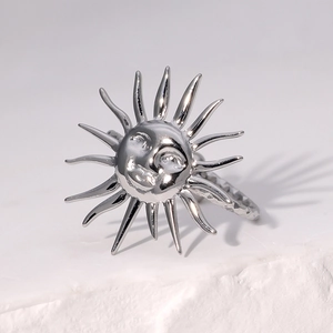 Vue macro d'une bague argentée avec relief de dieu du soleil sur fond de pierre blanche
