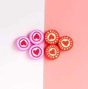 Detailed view of colorful clay beads featuring heart patterns for DIY jewelry making
