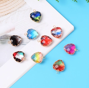 Macro detail of multi-colored glass heart pendants with gold-plated metal edges and loops