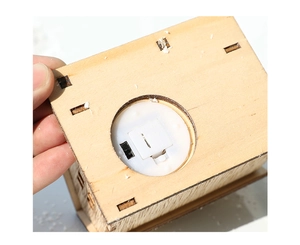 Detailed base view of the wooden Christmas cottage showing battery compartment and switch