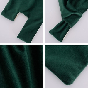 Close-up of deep green velvet fabric texture and white inner lining of the wrist bag