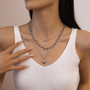 Three-layer silver necklace set featuring cowboy boot, bull skull and hat pendants