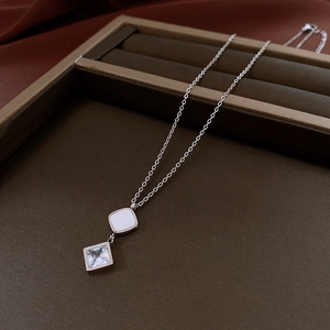 Macro shot of silver necklace with square mother of pearl and cubic zirconia pendant