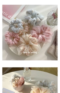 Close-up of assorted floral organza scrunchies in pastel colors and soft pleats