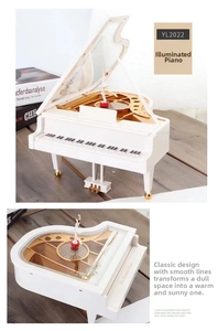 Detailed view of white piano music box with rotating ballerina and gold movement parts