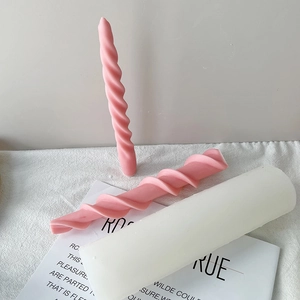 Detailed view of spiral pink candles and thick white candle on a magazine background