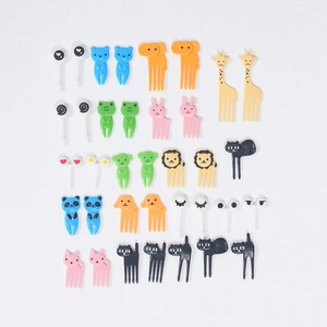 Flat lay of colorful plastic animal-shaped fruit picks including bears and giraffes