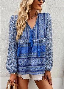 Detail shot of bohemian blue floral print shirt featuring tassels and long sleeves