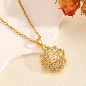 Détail macro d'un collier pendentif fleur dorée avec zircon et perles sur soie