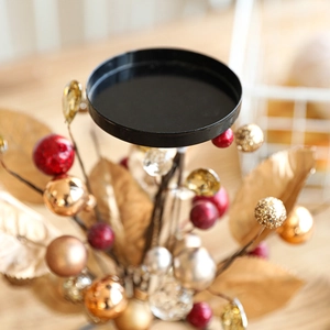 Modern black iron Christmas candle holder with golden leaves and colorful berry ornaments