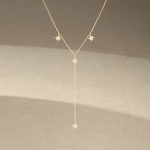 Detailed macro view of long Y-shaped gold star necklace with shimmering zircon stones