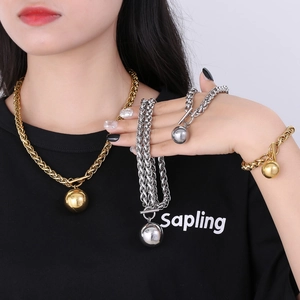 Close-up of industrial metal jewelry set with hollow ball pendant and OT toggle buckle