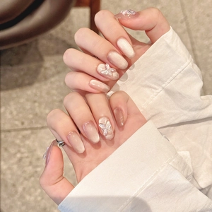 Handmade press-on nails with nude cat-eye effect and 3D crystal butterfly decorations