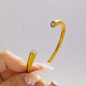 Minimalist gold open cuff bracelet with white pearls and sparkling rhinestone accents