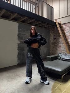Full view of oversized washed dark grey sweatshirt and joggers set in industrial studio