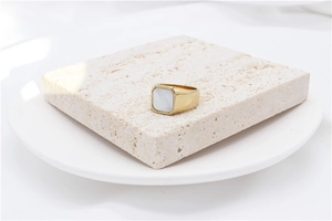 Macro shot of gold square signet ring with white mother of pearl inlay on stone