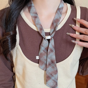 Close-up of a plaid acrylic chiffon scarf necklace with a white buckle detail
