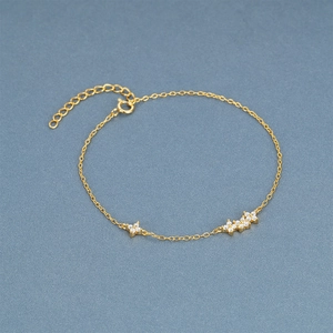 Detail of gold chain bracelet with delicate floral zircon charms and adjustable clasp
