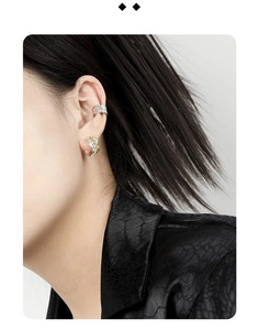 Detail of silver and gold textured ear cuff and wavy earring on ear model