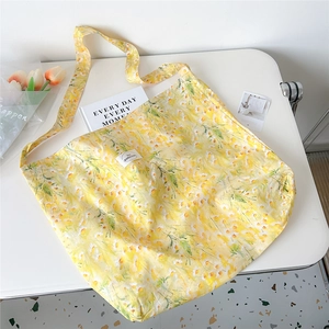Detailed top view of large yellow floral canvas tote bag with book and tulip decor