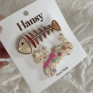 Détail de barrettes chat et arête de poisson en acétate aux motifs colorés et brillants