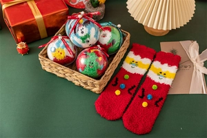 Détail de chaussettes de Noël en polaire corail présentées dans des boîtes cadeaux festives