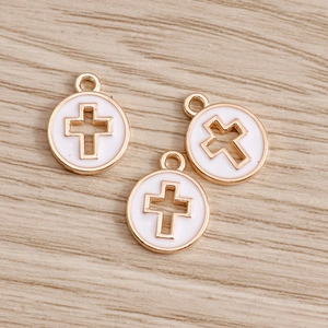 Close-up of golden hollow cross round charms on a minimalist light wood background