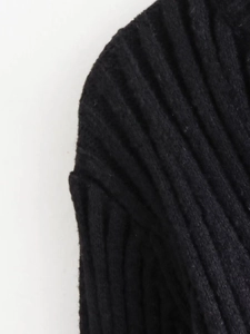 Detailed view of the shoulder seam on a black ribbed knit dress with vertical texture