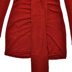 Détail du tissu pailleté rouge avec fronces et longue ceinture sur la robe