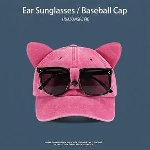 Close-up of pink baseball cap with cat ears and integrated black sunglasses for sun protection