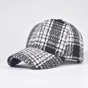 Close-up of thick black and white plaid baseball cap with detailed woolen fabric texture