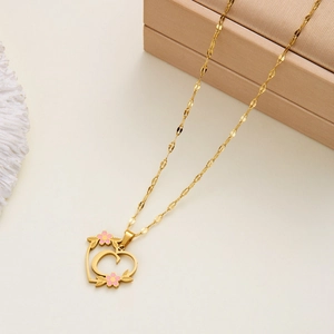 Detailed shot of golden heart necklace with letter C and pink flower accents