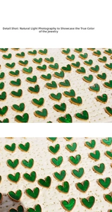 Detail of green heart earrings with gold trim arranged on white textured leather