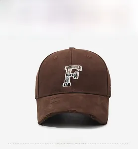 Detailed embroidery of letter F on a distressed dark brown vintage cotton baseball cap