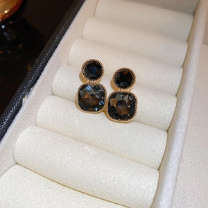 Detail view of vintage geometric gold earrings with black and grey square stones