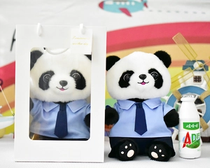Detailopname van een schattige panda knuffel met blauw shirt en witte geschenkdoos